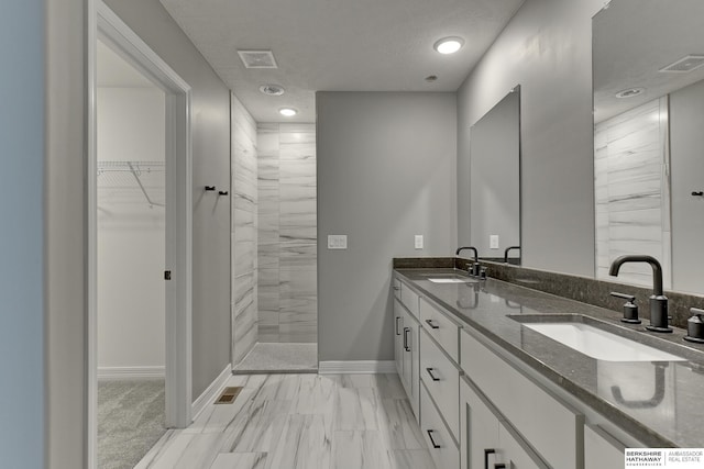 bathroom featuring a shower and vanity