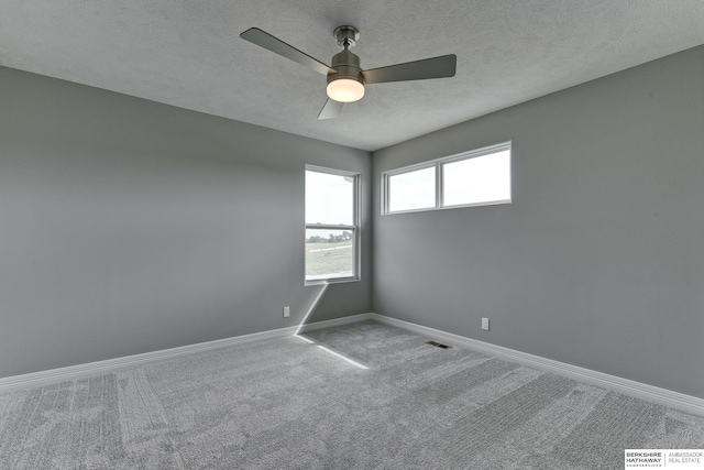 carpeted spare room with ceiling fan and a textured ceiling