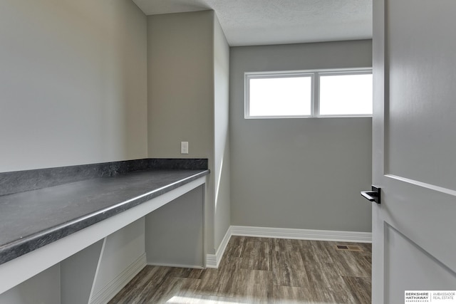 laundry area featuring a textured ceiling and dark hardwood / wood-style floors