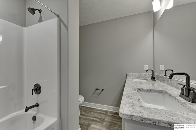 full bathroom featuring vanity,  shower combination, toilet, and a textured ceiling