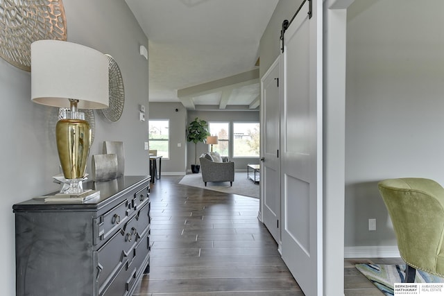 hallway featuring beam ceiling and a barn door