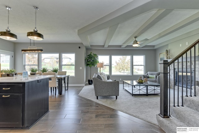 living room with beamed ceiling, ceiling fan, and a wealth of natural light