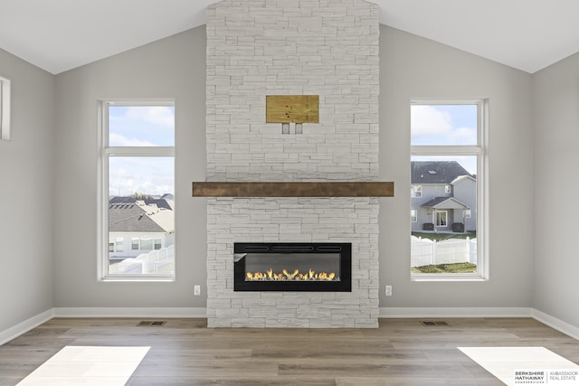 unfurnished living room with a fireplace, wood-type flooring, and vaulted ceiling