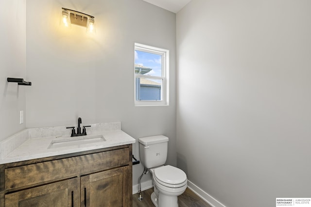 bathroom with hardwood / wood-style flooring, vanity, and toilet