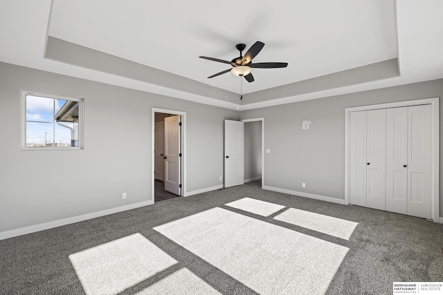 unfurnished bedroom with a closet, a raised ceiling, and ceiling fan