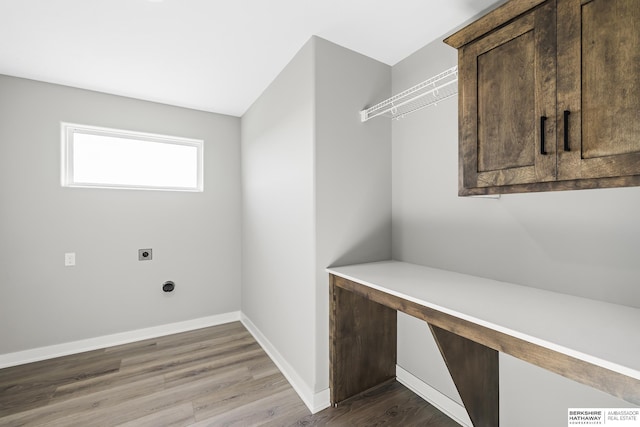 laundry room featuring hookup for an electric dryer, hardwood / wood-style flooring, and cabinets