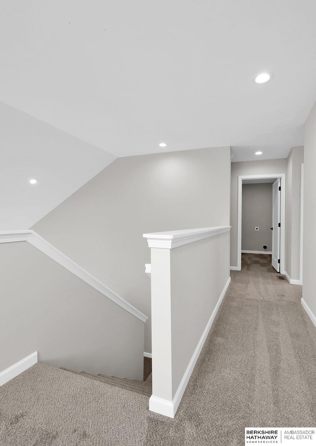 corridor with lofted ceiling and carpet flooring