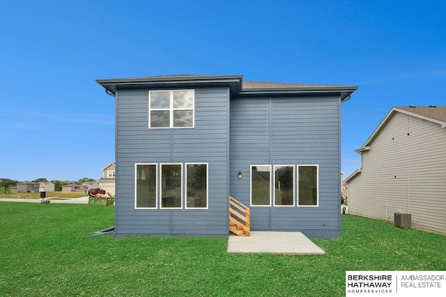 back of property with a yard, a patio, and central air condition unit