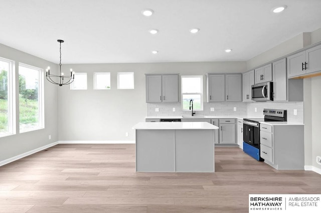 kitchen with sink, gray cabinets, a center island, and appliances with stainless steel finishes