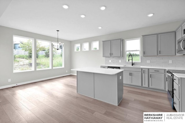 kitchen featuring a kitchen island, pendant lighting, tasteful backsplash, sink, and stainless steel appliances