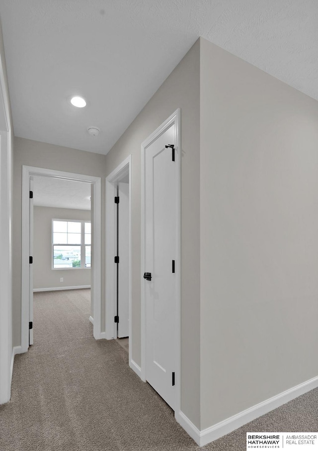 hallway with light colored carpet