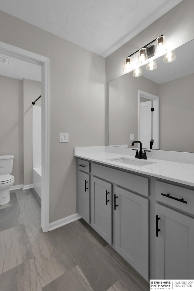 full bathroom with vanity, a textured ceiling, bathtub / shower combination, and toilet