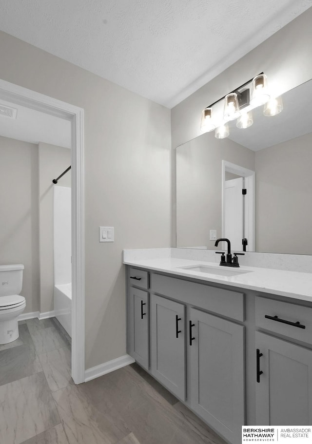 full bathroom with vanity, a textured ceiling, shower / washtub combination, and toilet