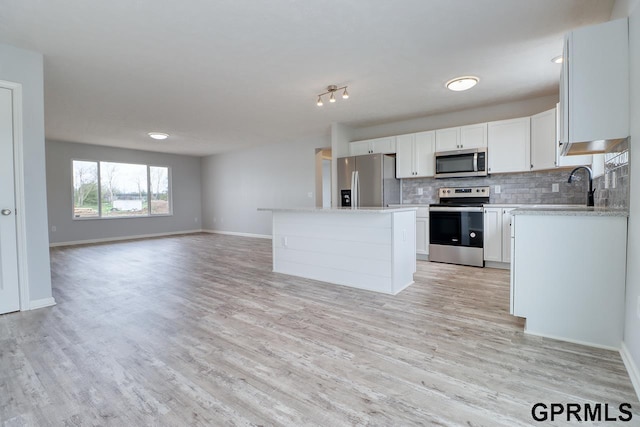 kitchen with tasteful backsplash, a center island, light hardwood / wood-style flooring, appliances with stainless steel finishes, and white cabinets