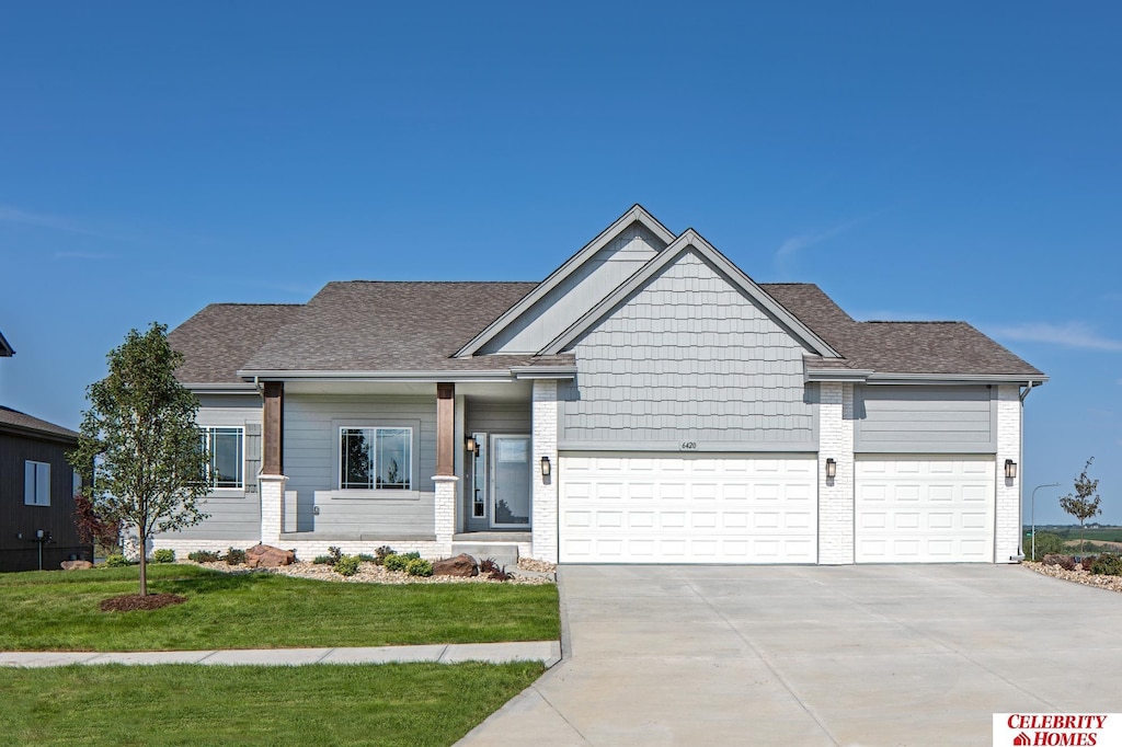 craftsman-style house featuring a garage and a front lawn