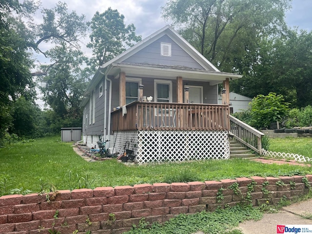 bungalow with a front lawn and covered porch