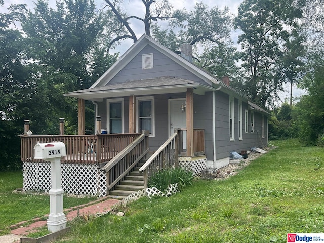 bungalow-style home with a front lawn and covered porch