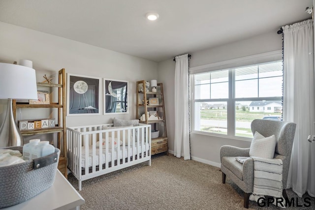 bedroom featuring carpet flooring and a nursery area