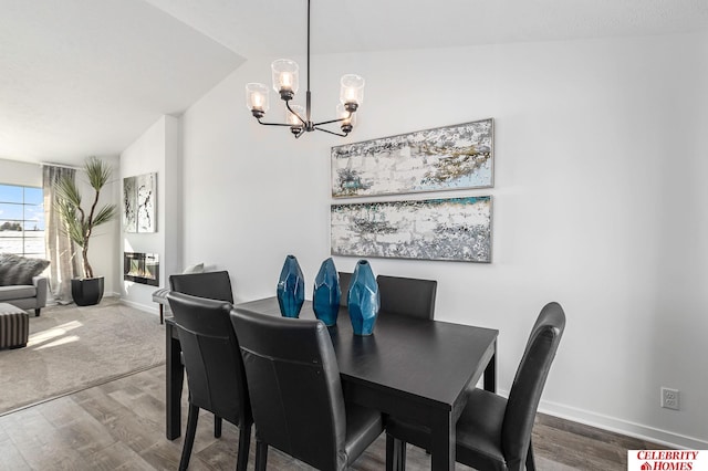 dining room featuring lofted ceiling, a notable chandelier, and hardwood / wood-style floors