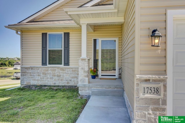 view of exterior entry with a yard