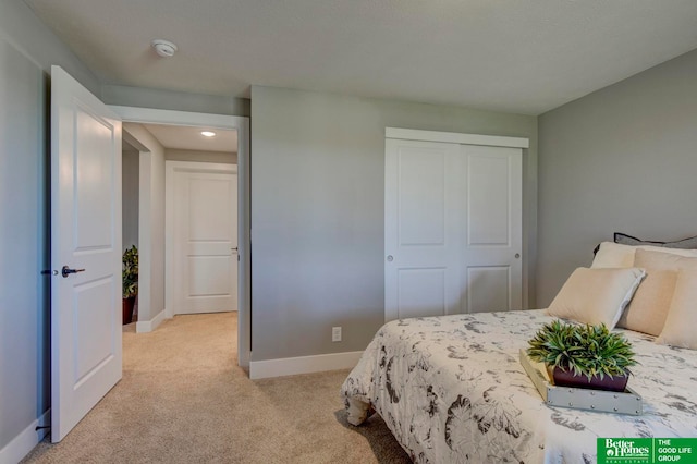 bedroom featuring light colored carpet and a closet