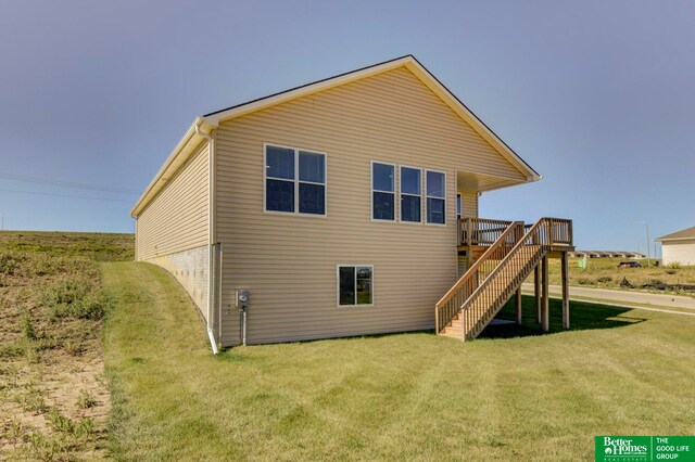 rear view of property with a yard and a deck