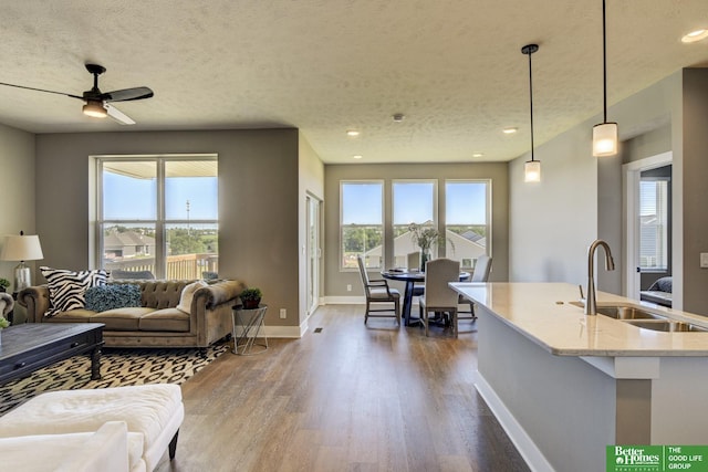 living area featuring a textured ceiling, ceiling fan, baseboards, and dark wood-style flooring