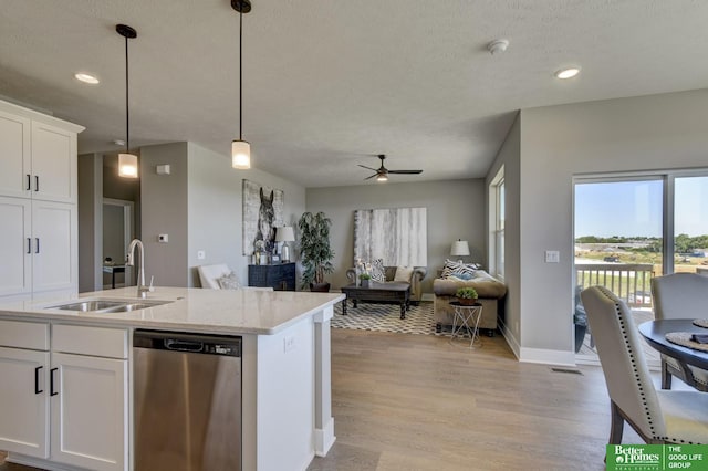 kitchen featuring a sink, stainless steel dishwasher, open floor plan, light wood-style floors, and ceiling fan