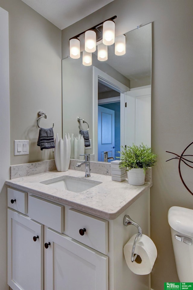 bathroom with toilet and large vanity