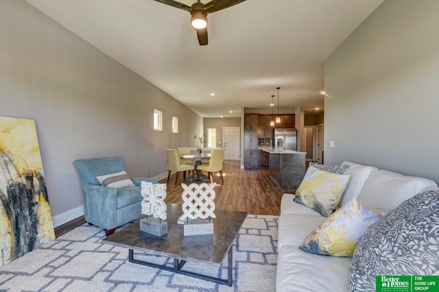 living room featuring wood-type flooring and ceiling fan