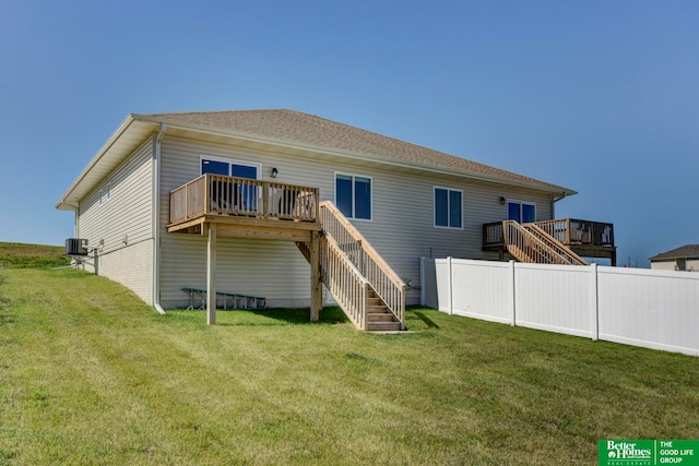 rear view of house featuring central AC unit, a lawn, and a wooden deck