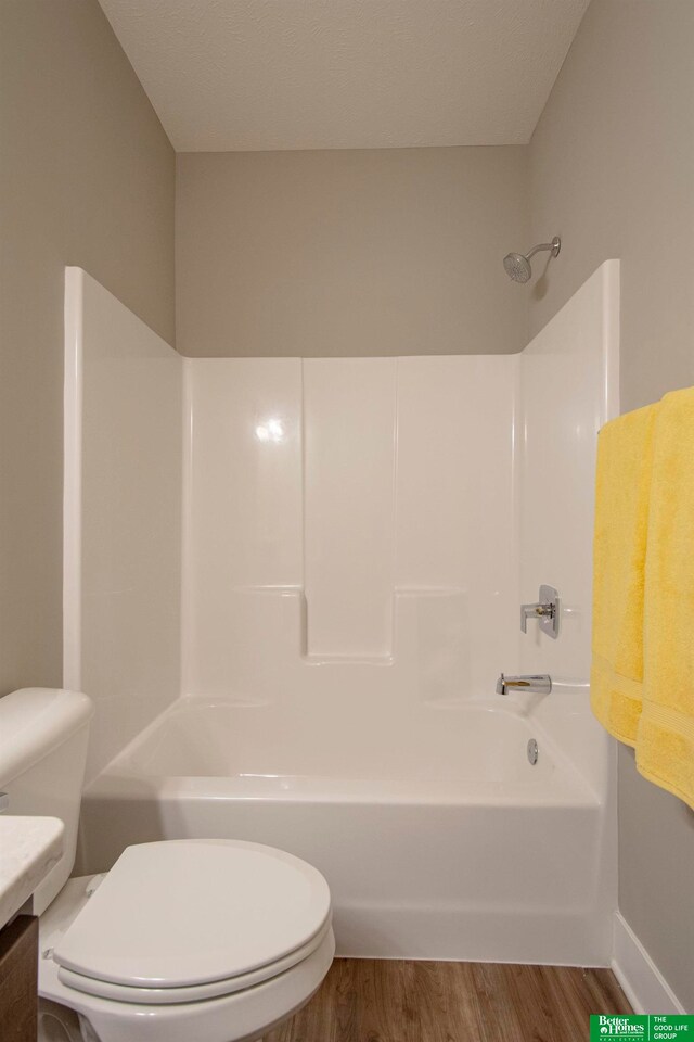 full bathroom with tub / shower combination, vanity, toilet, and hardwood / wood-style floors