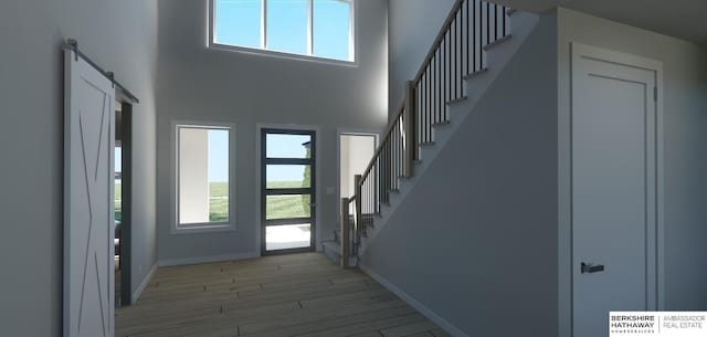 22742 Sanctuary Ridge Dr, Elkhorn, NE 68022 - entryway featuring a high ceiling, a barn door, plenty of natural light, and light hardwood / wood-style floors