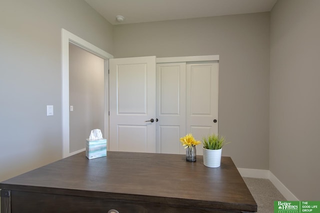 unfurnished office featuring carpet floors and baseboards