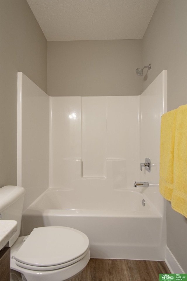 full bath featuring vanity, baseboards, shower / bath combination, toilet, and wood finished floors