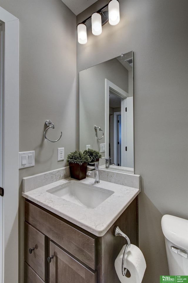 half bathroom with vanity and toilet