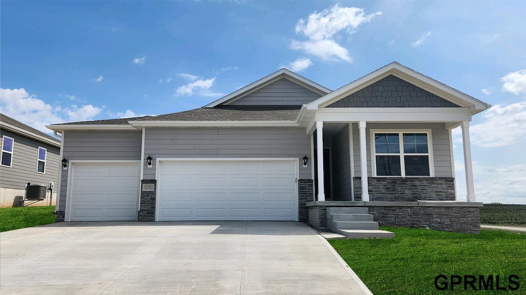 view of front of home featuring a garage and central AC unit