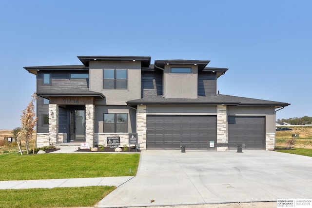 prairie-style house featuring a garage and a front lawn