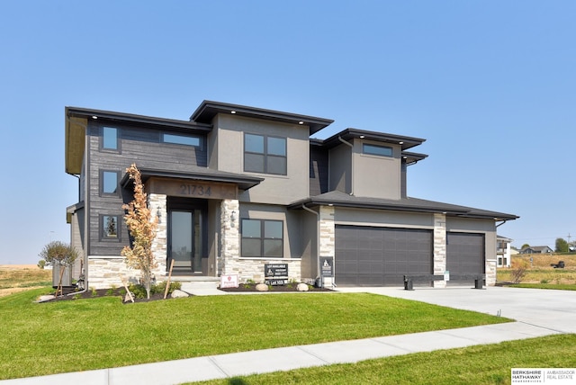 prairie-style home with a front lawn and a garage