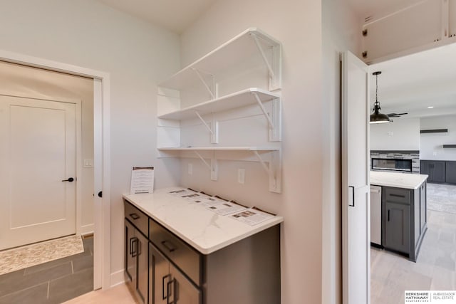 kitchen featuring light stone countertops and dark brown cabinetry