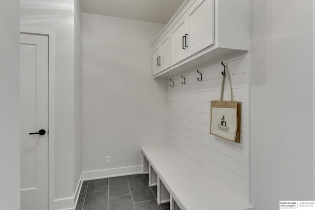 mudroom with dark tile patterned floors