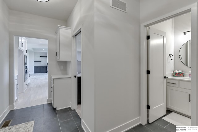 hall featuring dark tile patterned flooring