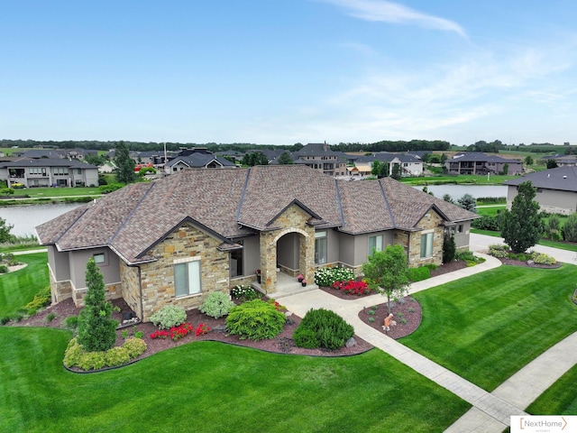 view of front of house with a front lawn and a water view