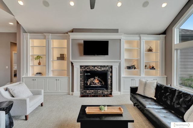 carpeted living room featuring ceiling fan, a fireplace, and lofted ceiling