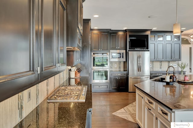 kitchen featuring pendant lighting, dark brown cabinets, stainless steel appliances, and dark hardwood / wood-style floors