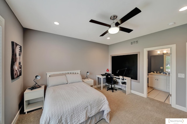 bedroom with connected bathroom, ceiling fan, and light carpet