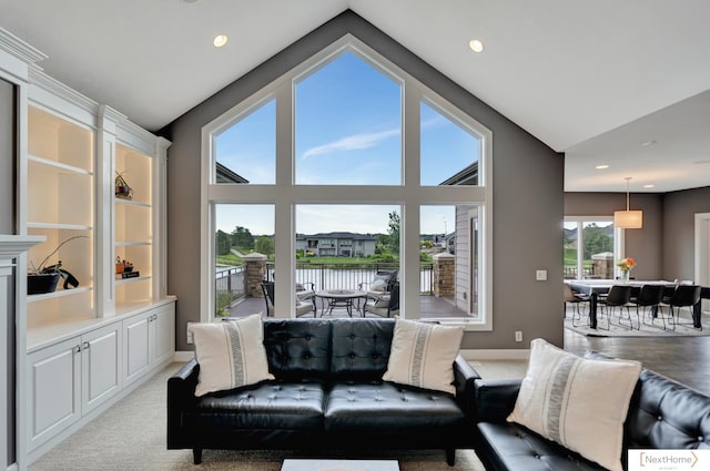 living room featuring light carpet, a water view, and lofted ceiling