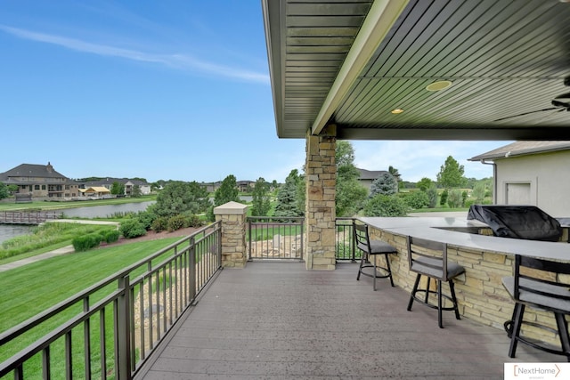 view of patio featuring a water view and exterior bar