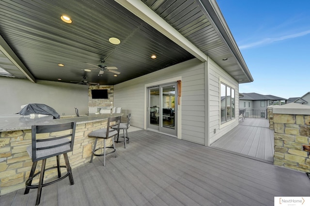 deck with a bar and ceiling fan