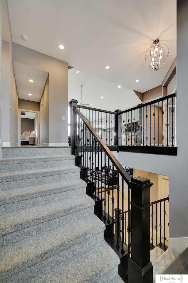 staircase with ceiling fan with notable chandelier